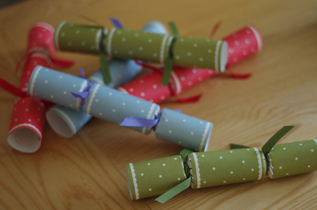 Color photograph of a stack of Christmas crackers in red, green, and blue.